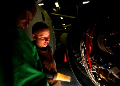 US Navy 041028-N-5345W-010 Aviation Boatswain's Mate 3rd Class John Njau and Aviation Machinist's Mate Airman Mitchell Driver perform engine maintenance on an S-3B Vikings