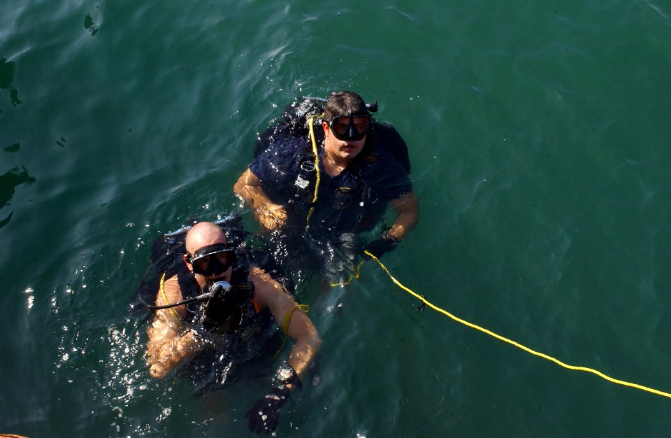 US Navy 041103-F-2760K-003 U.S. Navy divers assigned to Explosive Ordnance Disposal Mobile Unit Eight (EODMU-8), Detachment Eighteen, surface after the strenuous task of underwater Explosive Ordnance Disposal sweeps