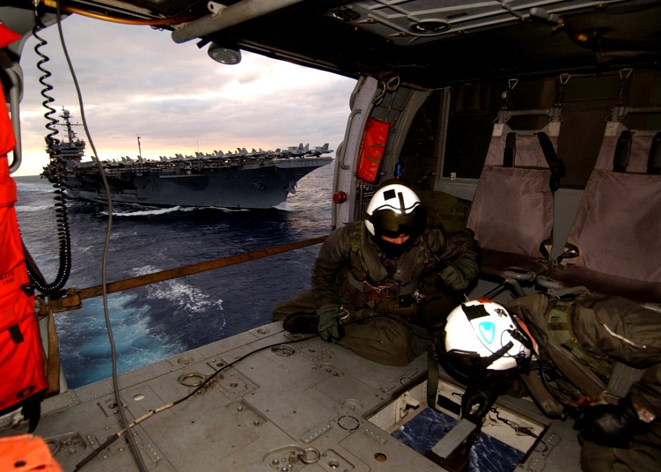 US Navy 041206-N-4374S-005 Aircrewmen prepare to receive a cargo pallet from the fast combat support ship USS Seattle (AOE 3) during a vertical replenishment at sea as the conventionally powered aircraft carrier USS John F. Ken