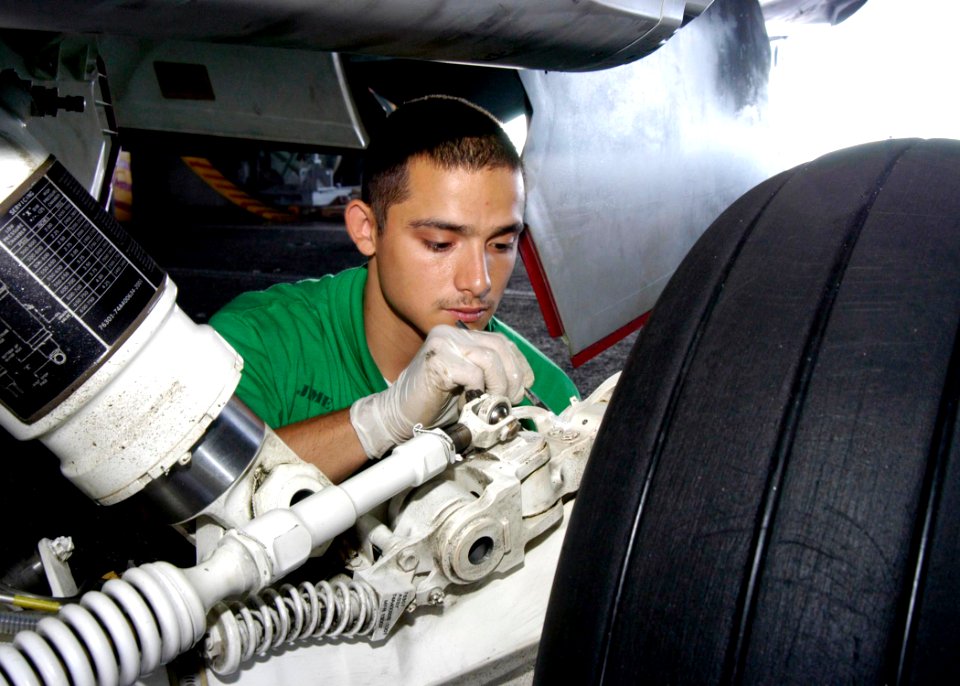 US Navy 041117-N-7816R-012 Aviation Structural Mechanic 3rd Class Jimenez Jorge of Houston, Texas, paints the landing gear assembly on an F-A-18E Super Hornet