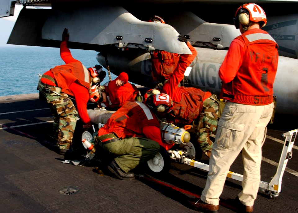 US Navy 041211-N-4953E-172 Aviation Ordnancemen assigned to the Gunslingers of Strike Fighter Squadron One Zero Five (VFA-105) load a 500-pound laser guided bomb (GBU-12) on an F-A-18 Hornet