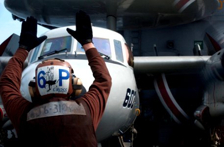 US Navy 041116-N-0989T-009 A plane captain uses hand signals to communicate with the air crew of an E-2C Hawkeye aircraft