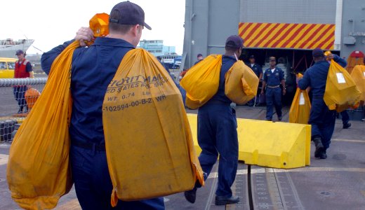 US Navy 041107-N-2653P-510 Crew members aboard the guided missile frigate USS Halyburton (FFG 40) carry mail aboard ship after arriving in the port of Manta, Ecuador for a scheduled port call photo
