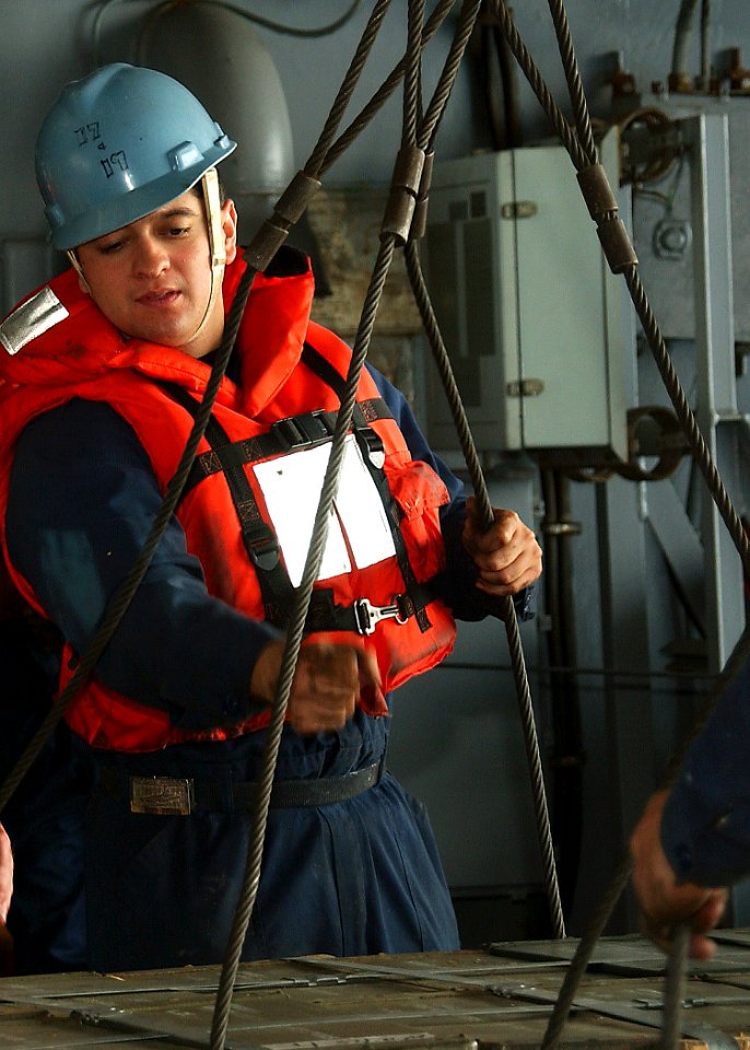 US Navy 041116-N-4561B-008 Seaman Ruben Nevarez of El Paso, Texas, attaches a sling to a pallet of ammunition being transported from USS George Washington (CVN 73) to the Military Sealift Command (MSC) fast combat supply ship U