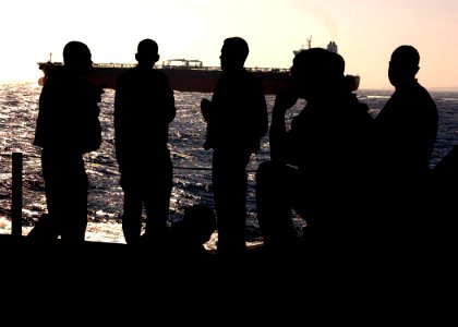 US Navy 041112-N-2984R-048 Sailors assigned to the V-3 Hangar Deck Department look on as the Nimitz-class aircraft carrier USS Harry S. Truman (CVN 75) pass by a merchant ship exiting the Suez canal