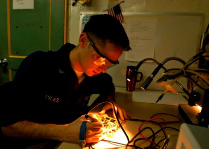 US Navy 041114-N-9079D-006 Electronics Technician 3rd Class Michael Lucas makes repairs on a circuit board for a NATO RIM-7 Sea Sparrow launcher aboard the Nimitz-class aircraft carrier USS Abraham Lincoln (CVN 72) photo