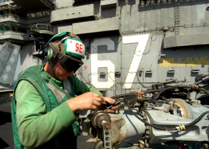 US Navy 041007-N-8704K-001 An Aviation Machinist Mate performs maintenance on the main rotor of an SH-60B Seahawk
