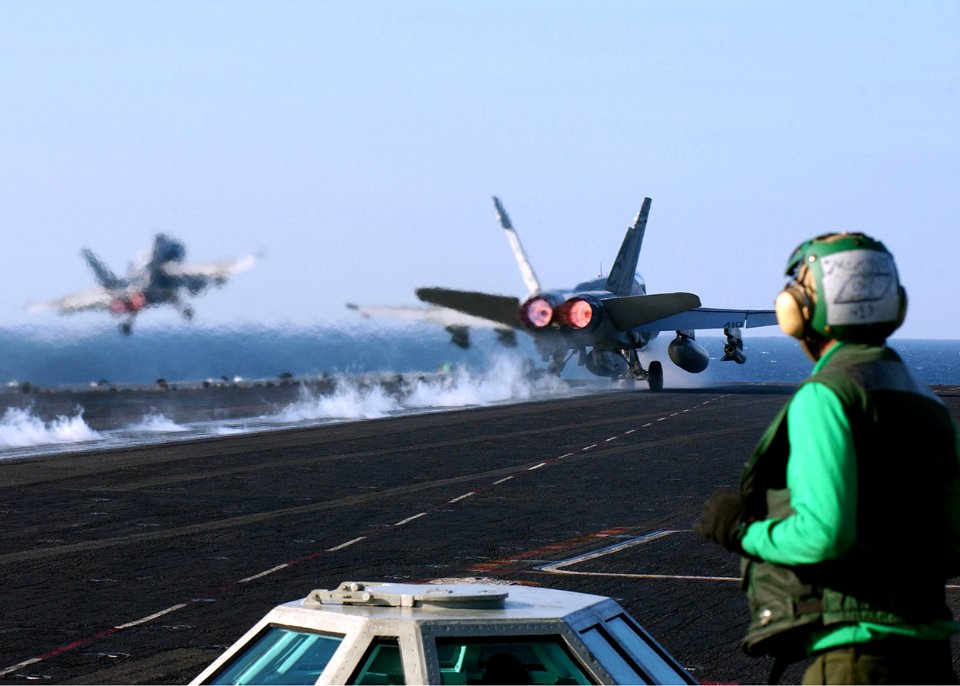 US Navy 041231-N-5345W-037 A Sailor watches as two F-A-18C Hornets launch from the flight deck aboard the Nimitz-class aircraft carrier USS Harry S. Truman (CVN 75)