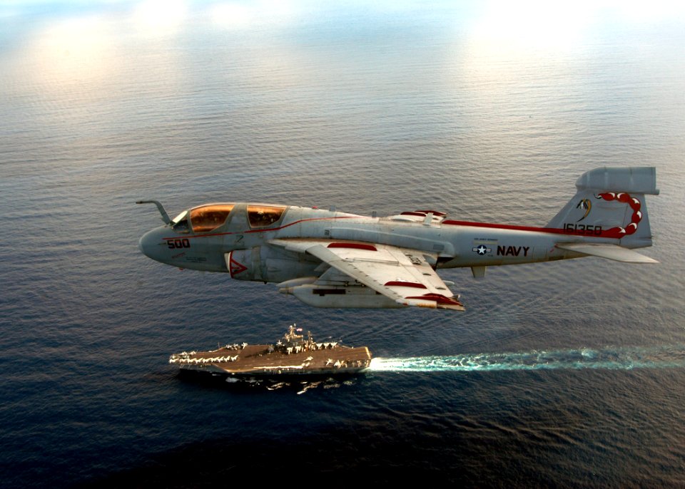 US Navy 041205-N-8704K-005 An EA-6B Prowler flies over the conventionally powered aircraft carrier USS John F. Kennedy (CV 67) after completing routine flight operations in the Atlantic Ocean