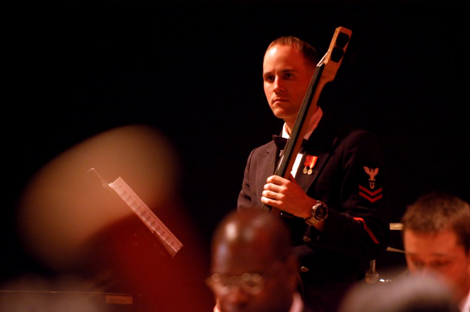 US Navy 041219-N-1194D-123 Musician 2nd Class Luke Peeling plays the bass guitar during a holiday concert