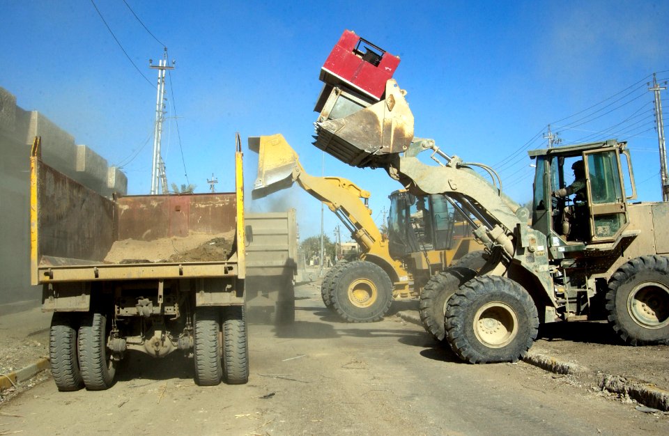 US Navy 041213-N-4614W-019 A U.S. Marine Corps front-end loader joins its Army counterpart in filling contracted Iraqi dump trucks with dirt