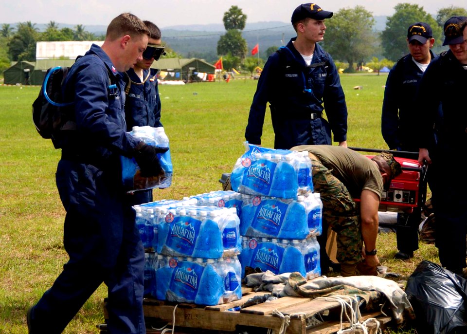 US Navy 050103-N-0057P-341 Sailors, assigned to USS Abraham Lincoln (CVN 72) and embarked Carrier Air Wing Two (CVW-2), stack bottled water prior to distribution to Tsunami victims in Aceh, Sumatra, Indonesia