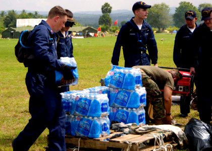 US Navy 050103-N-0057P-341 Sailors, assigned to USS Abraham Lincoln (CVN 72) and embarked Carrier Air Wing Two (CVW-2), stack bottled water prior to distribution to Tsunami victims in Aceh, Sumatra, Indonesia