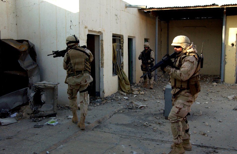 US Navy 041209-N-4614W-028 Navy Reserve Chief Engineering Aide Ardell Ball, right, leads his team of Seabees into a former agricultural building in the city of Fallujah, Iraq