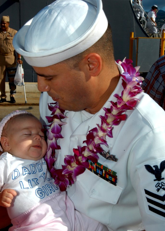 US Navy 041209-N-3019M-009 Storekeeper 1st Class George Moran, assigned to the Arleigh Burke-class guided missile destroyer USS Hopper (DDG 70), holds his newborn baby girl after returning from a six-month deployment in support