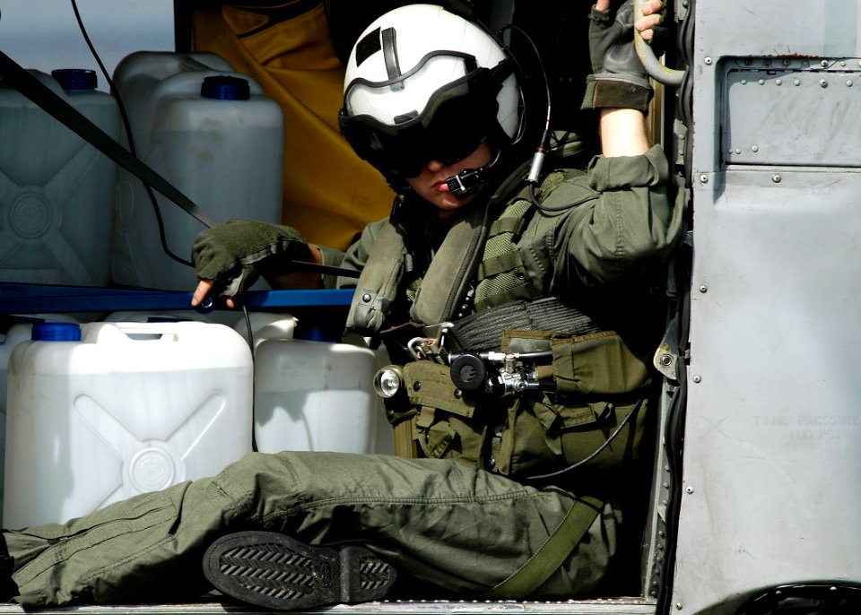 US Navy 050105-N-4166B-030 An air crewman sits in the cabin of an HH-60H Seahawk helicopter full of purified water jugs