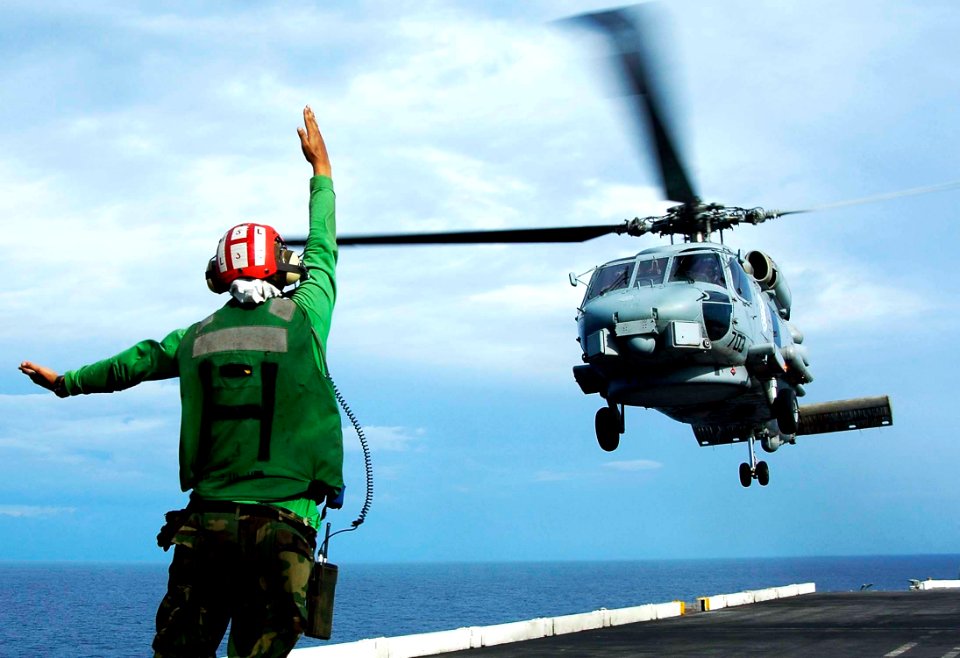 US Navy 050103-N-6074Y-197 A Landing Signals Enlisted (LSE) direct an SH-60B Seahawk assigned to the Saberhawks of Helicopter Anti-Submarine Light Squadron Four Seven (HSL-47) to depart the flight deck of USS Abraham Lincoln (C