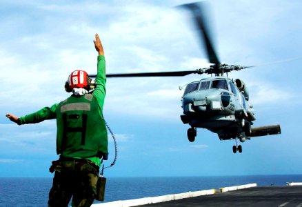 US Navy 050103-N-6074Y-197 A Landing Signals Enlisted (LSE) direct an SH-60B Seahawk assigned to the Saberhawks of Helicopter Anti-Submarine Light Squadron Four Seven (HSL-47) to depart the flight deck of USS Abraham Lincoln (C