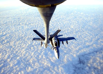 US Navy 041212-N-0000X-002 An F-A-18C Hornet assigned to the Gunslingers of Strike Fighter Squadron One Zero Five (VFA-105) receives refuels from an Air Force KC-130 photo