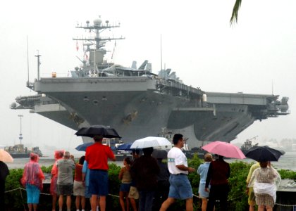 US Navy 041105-N-3019M-003 Visitors at the USS Arizona Memorial Visitor Center watch the Nimitz-class aircraft carrier USS Abraham Lincoln (CVN 72) arrive in Pearl Harbor for a port visit