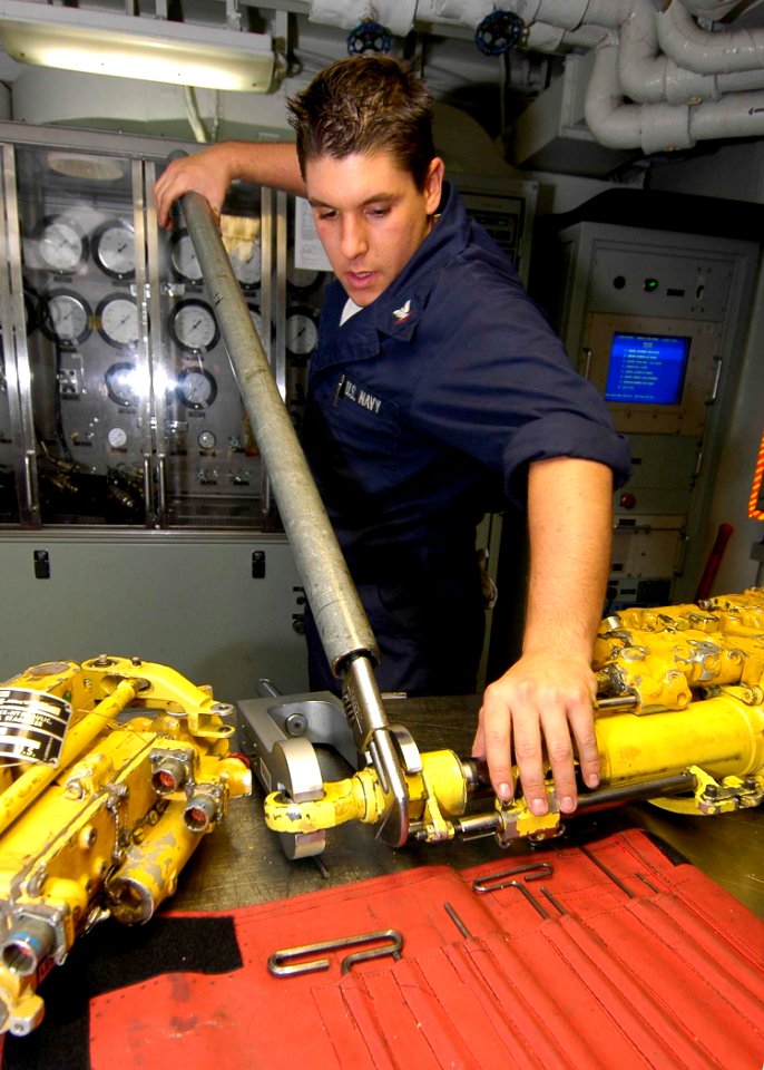 US Navy 041222-N-6074Y-056 Aviation Structural Mechanic 3rd Class Ryan Wilmarth gets ready to loosen a hex nut on the hydraulic portion of a horizontal stabilizer from an F-A-18F Hornet
