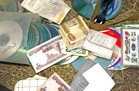 US Navy 041223-N-4614W-054 A young Iraqi boy lead U.S. Army Soldiers to a cache of money, CD-ROMS, wiring, car remotes and an AK-47 assault rifle with five magazines in the city of Baghdad, Iraq photo