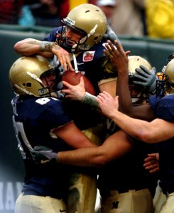 US Navy 041230-N-9693M-005 U.S. Naval Academy Midshipman 1st Class Aaron Polanco celebrates his touchdown with members of the offensive line in the 1st quarter of play against the Lobos of New Mexico at the Emerald Bowl in San