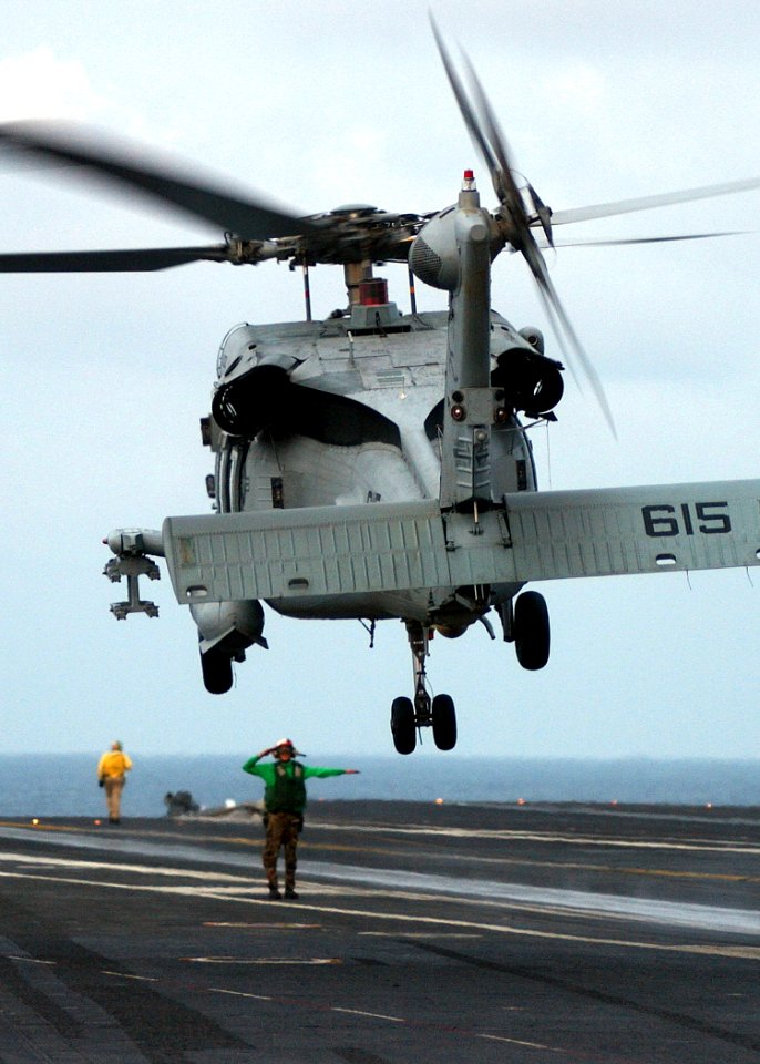 US Navy 041115-N-5345W-121 Aviation Electrician's Mate 3rd Class Megan Truncer, a Landing Signal Enlistedman (LSE), communicates with the pilot of an HH-60H Seahawk during flight preparations