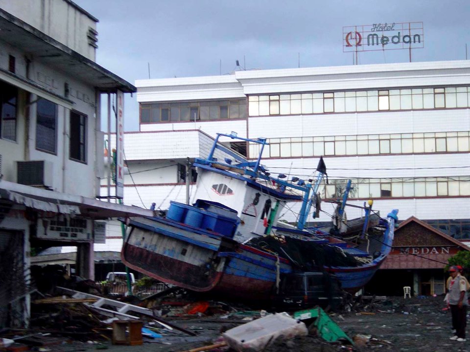 US Navy 050101-O-XXXXB-054 Boats washed ashore near local businesses in down town Aceh, Sumatra following a massive Tsunami that struck the area on the 26th of December 2004