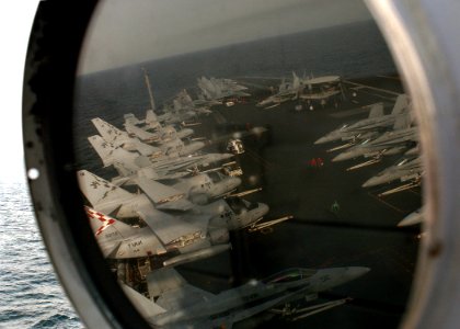 US Navy 041119-N-5345W-092 Aircraft await flight operations on the flight deck of Nimitz-class aircraft carrier USS Harry S. Truman (CVN 75) as they are viewed in the reflection of a signal light atop the ship's island
