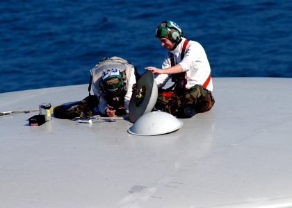 US Navy 050102-N-6363M-017 Aviation Electronics Technician 1st Class Michael Hunter, left, and Aviation Electronics Technician 2nd Class Thomas Graham work on an antenna on an E-2C Hawkeye aircraft