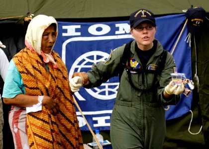 US Navy 050103-N-4166B-237 Lt. Jody Weinstein helps an injured Indonesian woman into a medical evacuation vehicle after she was transported from a coastal village on the island of Sumatra, Indonesia