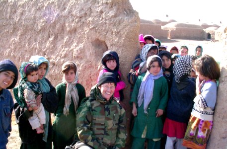 US Navy 050105-N-0000X-082 Cmdr. Kim Evans stops to take a photo with children from the Ghoryan District. Evans is the first female commanding officer of a Provincial Reconstruction Team in Afghanistan