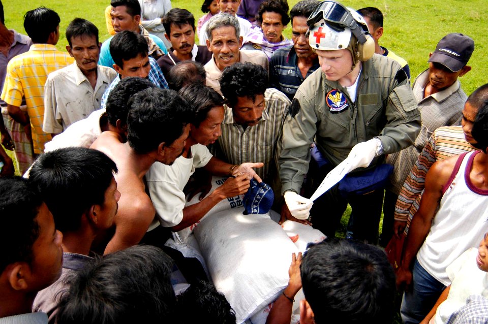 US Navy 050109-N-4166B-157 Hospital Corpsman 3rd Class Joseph Budke of Aurora, Colo., explains to local Indonesian citizens in Tjalang, Sumatra, Indonesia, an illustration that helps communicate the dangers of a helicopter,