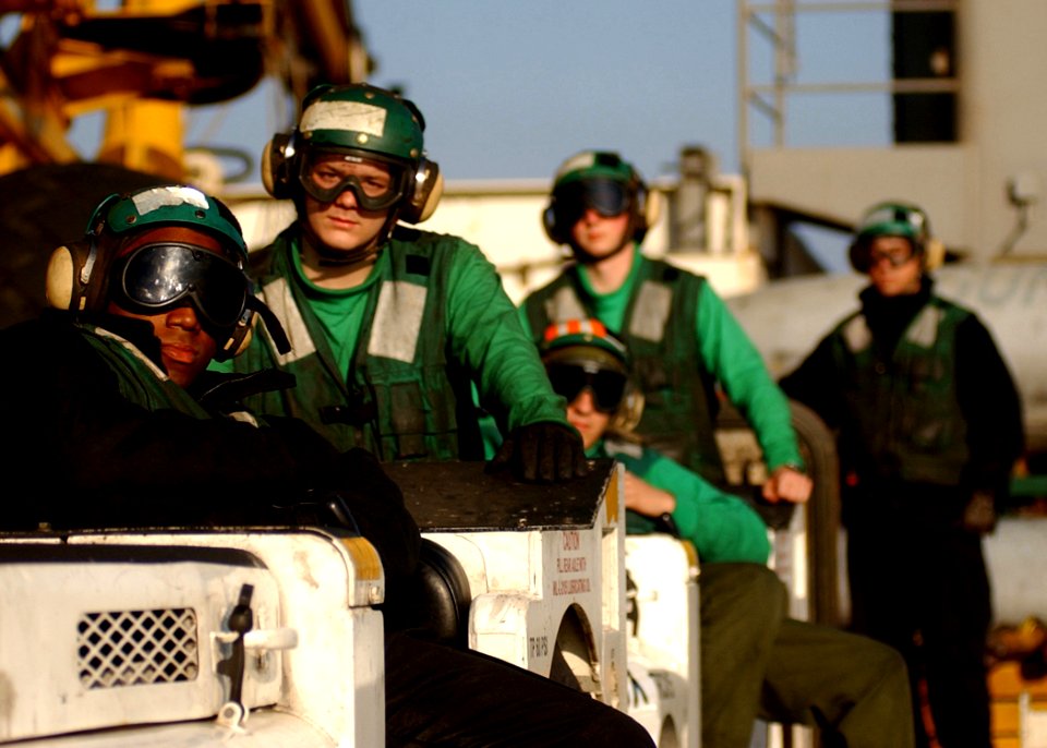 US Navy 050113-N-6363M-003 Sailors assigned to the Launch and Recovery Division in the Air Department, relax during a break in flight operations on the flight deck aboard USS Harry S. Truman (CVN 75)