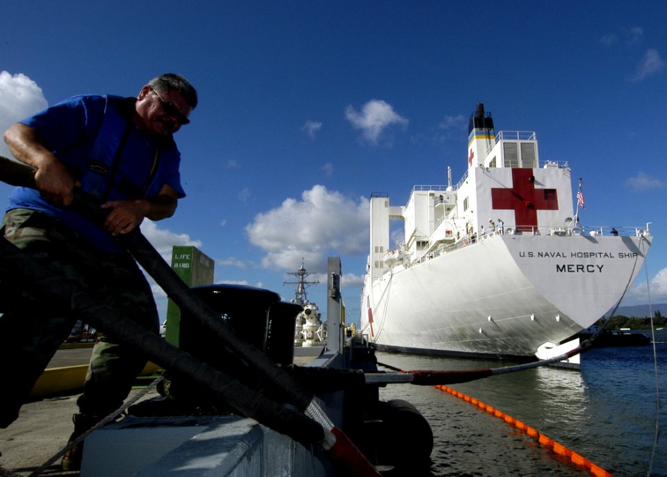 US Navy 050111-N-3019M-003 Nick Revuelto, a line handler for Naval Station Pearl Harbor, Hawaii, helps to get the Sealift Command (MSC) hospital ship USNS Mercy (T-AH 19) moored to the pier in Pearl Harbor for a brief port visi