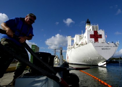US Navy 050111-N-3019M-003 Nick Revuelto, a line handler for Naval Station Pearl Harbor, Hawaii, helps to get the Sealift Command (MSC) hospital ship USNS Mercy (T-AH 19) moored to the pier in Pearl Harbor for a brief port visi