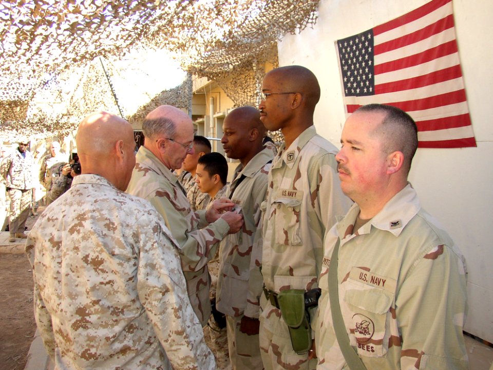 US Navy 050113-N-2757S-004 Chief of Naval Operations (CNO), Adm. Vern Clark, does the honors of awarding Fleet Marine Force warfare specialty pins to military members while visiting troops in the Middle East
