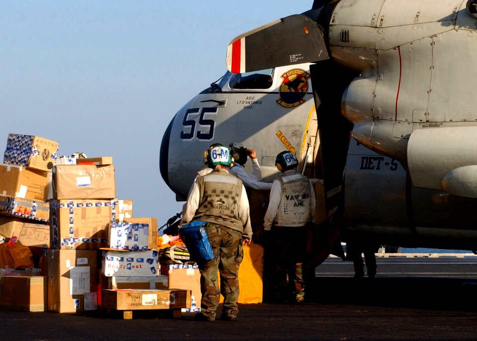 US Navy 050113-N-6363M-033 Sailors assigned to Carrier Airborne Early Warning Squadron One Two Six (VAW-126), help unload mail from a C-2A Greyhound