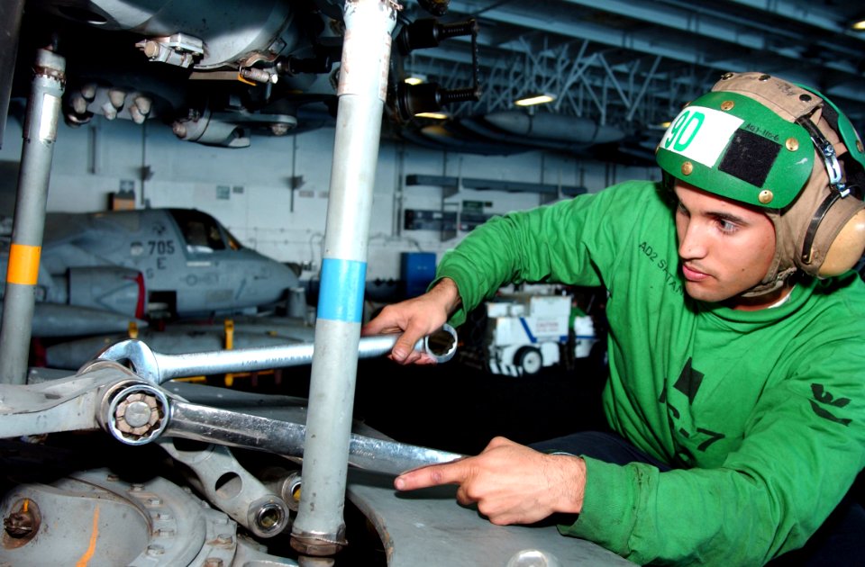 US Navy 041223-N-4584T-037 Aviation Machinist's Mate 2nd Class Manny Santana assigned to the Dusty Dogs of Helicopter Anti-Submarine Squadron Seven (HS-7), tightens a bolt on the rotor of a SH-60F Seahawk helicopter