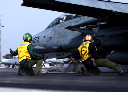 US Navy 050123-N-6363M-011 Aviation Boatswain's Mate 2nd Class Louis Martinez, left, and Timothy Stephenson waist safety observers give a ready-deck signal to launch an F-14B Tomcat assigned to the Swordsmenn of Fighter