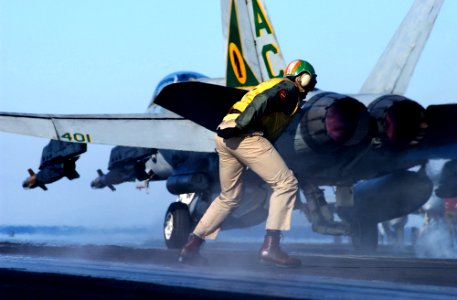 US Navy 041229-N-6363M-011 Aircraft shooter, LT Lamar Bradley, quickly recovers after shooting an F-A-18C Hornet