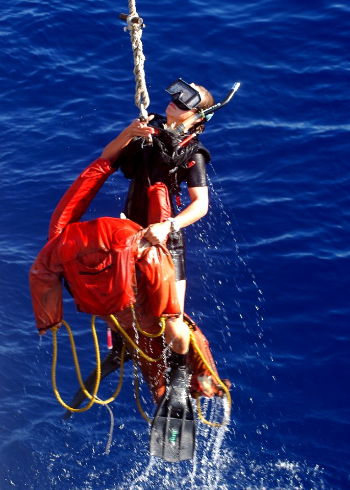 US Navy 050124-N-3019M-001 Search and Rescue Swimmer, Hospital Corpsman 3rd Class Amber Bouge lifts Oscar out of the water during a man overboard drill aboard the Safeguard-class rescue and salvage ship USS Salvor (ARS 52)