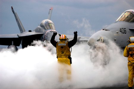 US Navy 050126-N-5781F-083 An Aviation Boatswain's Mate handler directs an F-A-18C Hornet assigned to the Dambusters of Strike Fighter Squadron One Nine Five (VFA-195) onto a catapult aboard USS Kitty Hawk (CV 63)