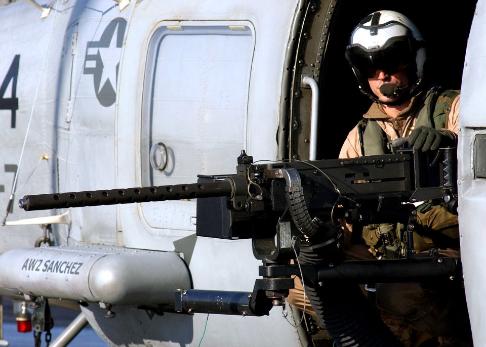 US Navy 041231-N-5345W-054 Aviation Warfare Systems Operator 3rd Class Ryan Branco mans a .50 caliber machine gun