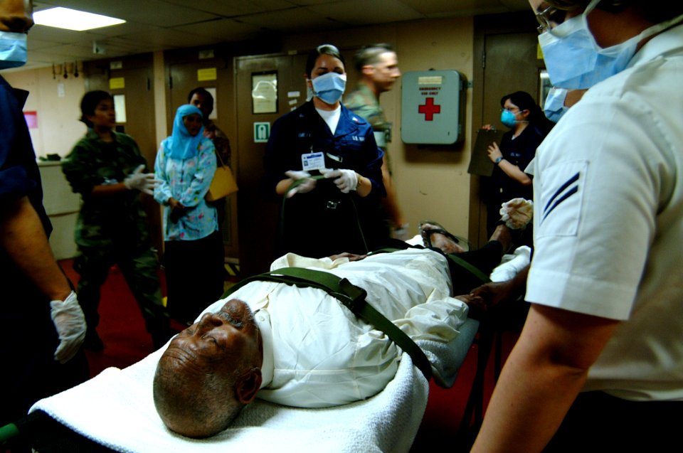 US Navy 050211-N-0357S-046 Hospital Corpsmen aboard the Military Sealift Command (MSC) hospital ship USNS Mercy (T-AH 19), prepare to take an elderly Indonesian man down the ship's elevator