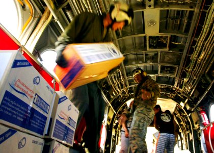 US Navy 050131-N-6074Y-158 Marines assigned to the Flying Tigers of Marine Medium Helicopter Squadron Two Six Two (HMM-262), move boxes of food out of the back of a CH-46E Sea Knight helicopter
