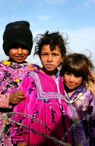 US Navy 050124-N-1810F-466 Local Iraqi children pose for a picture as they stand outside the barbed-wire barricades set up by Seabees prior starting work