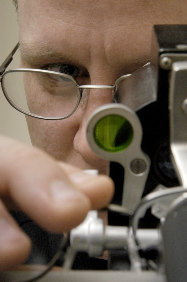 US Navy 050129-N-6477M-012 Hospital Corpsman David P. Taylor uses a lensometer to check the prescription of eye glasses in the optometry department