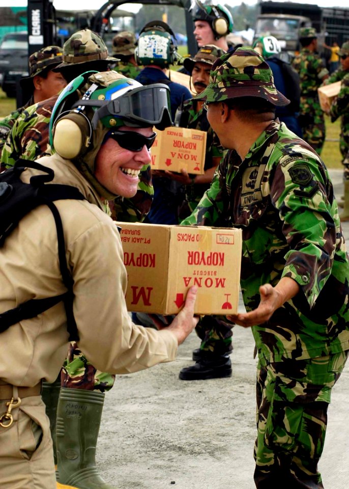 US Navy 050103-N-4166B-125 A Chief Petty Officer assigned to USS Abraham Lincoln (CVN 72) smiles as he and Indonesian Armed Forces personnel transfer supplies to an awaiting U.S. Navy helicopter